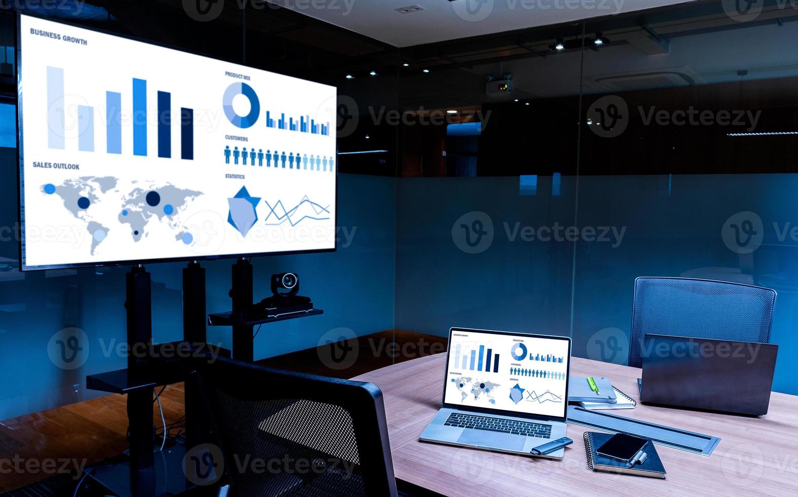 Slide show presentation on display television and laptop with notebook on table in meeting room photo