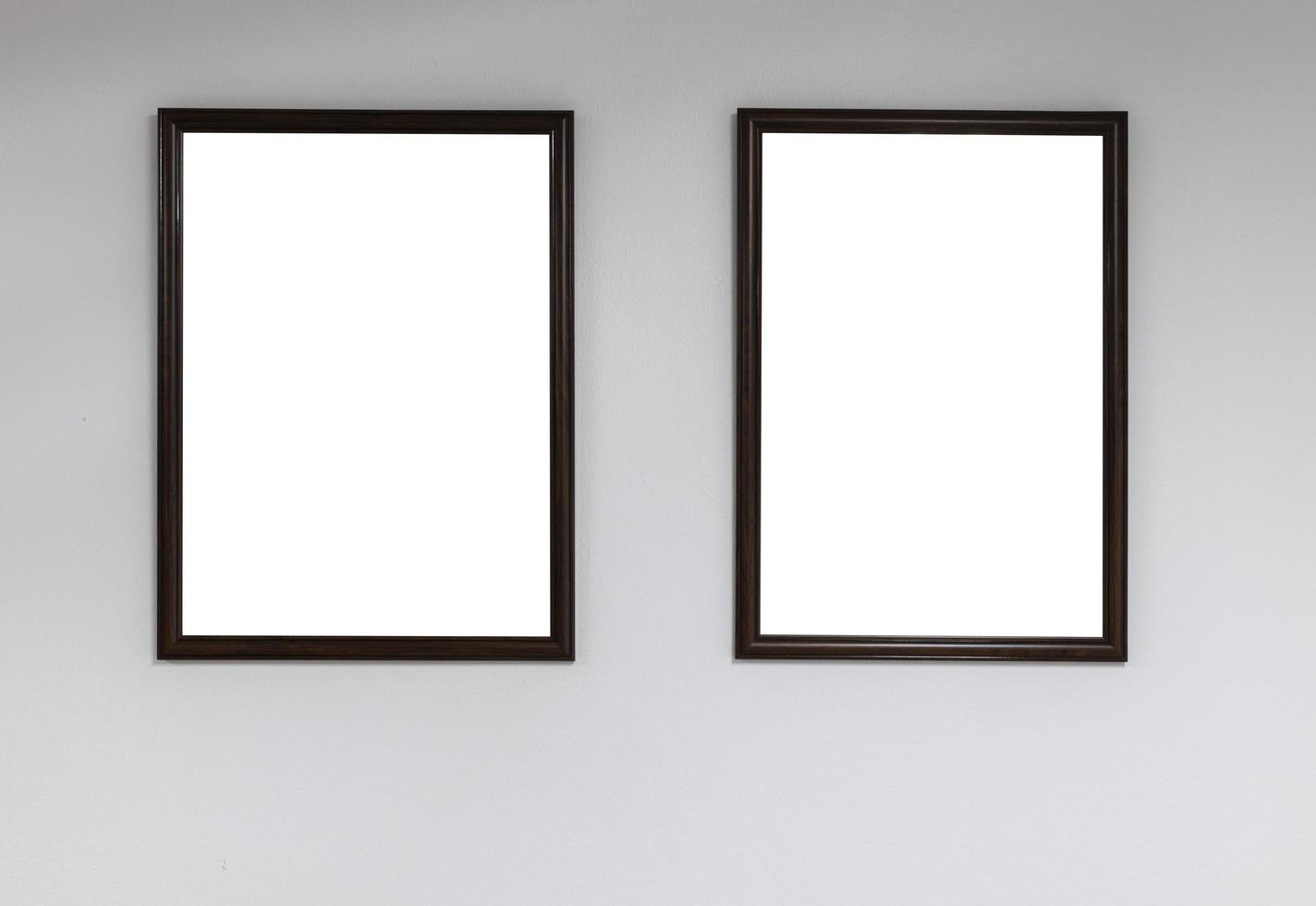 Two empty picture frames on a white wall photo