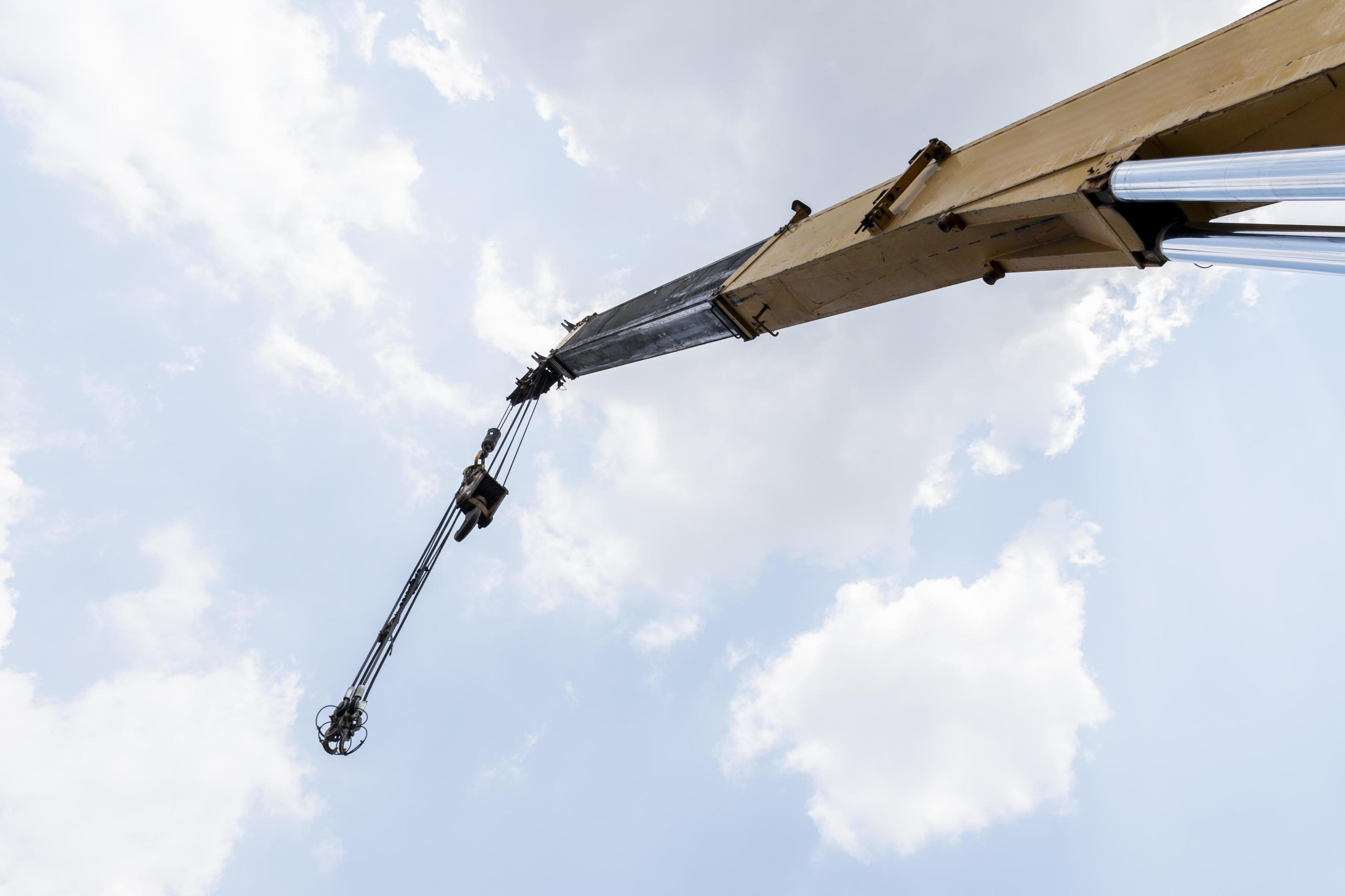 Yellow crane boom with hooks and blue sky background 16561509 Stock