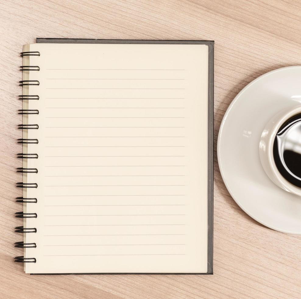Top view close up notebook and half coffee cup on table photo