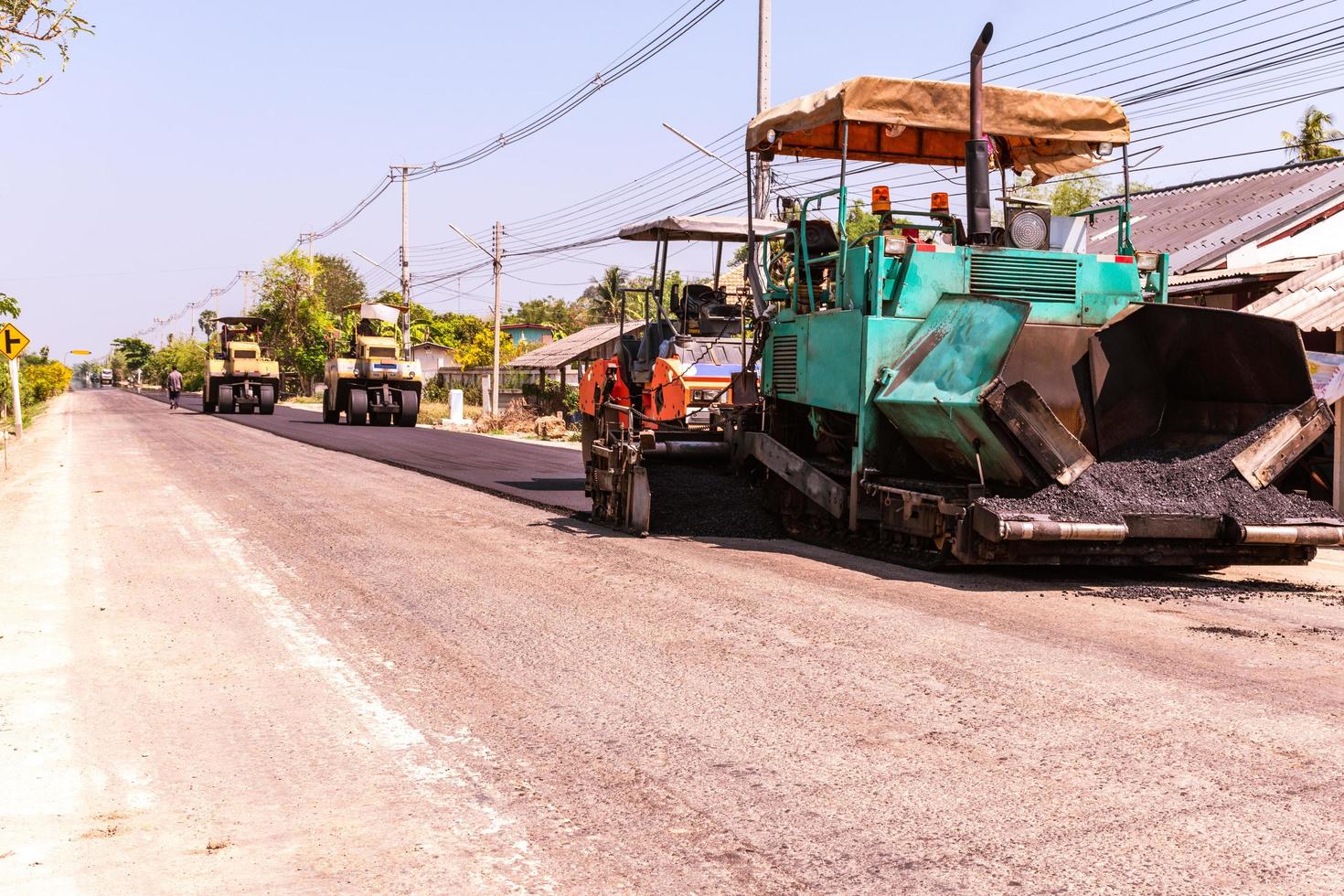 vista cercana de los trabajadores y las máquinas de asfaltado, trabajadores que hacen asfalto en la construcción de carreteras foto