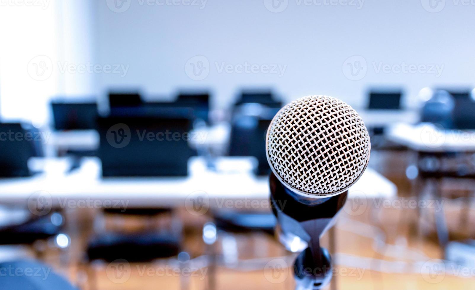 cerrar el micrófono con el portátil en el fondo de la mesa en la sala de seminarios foto