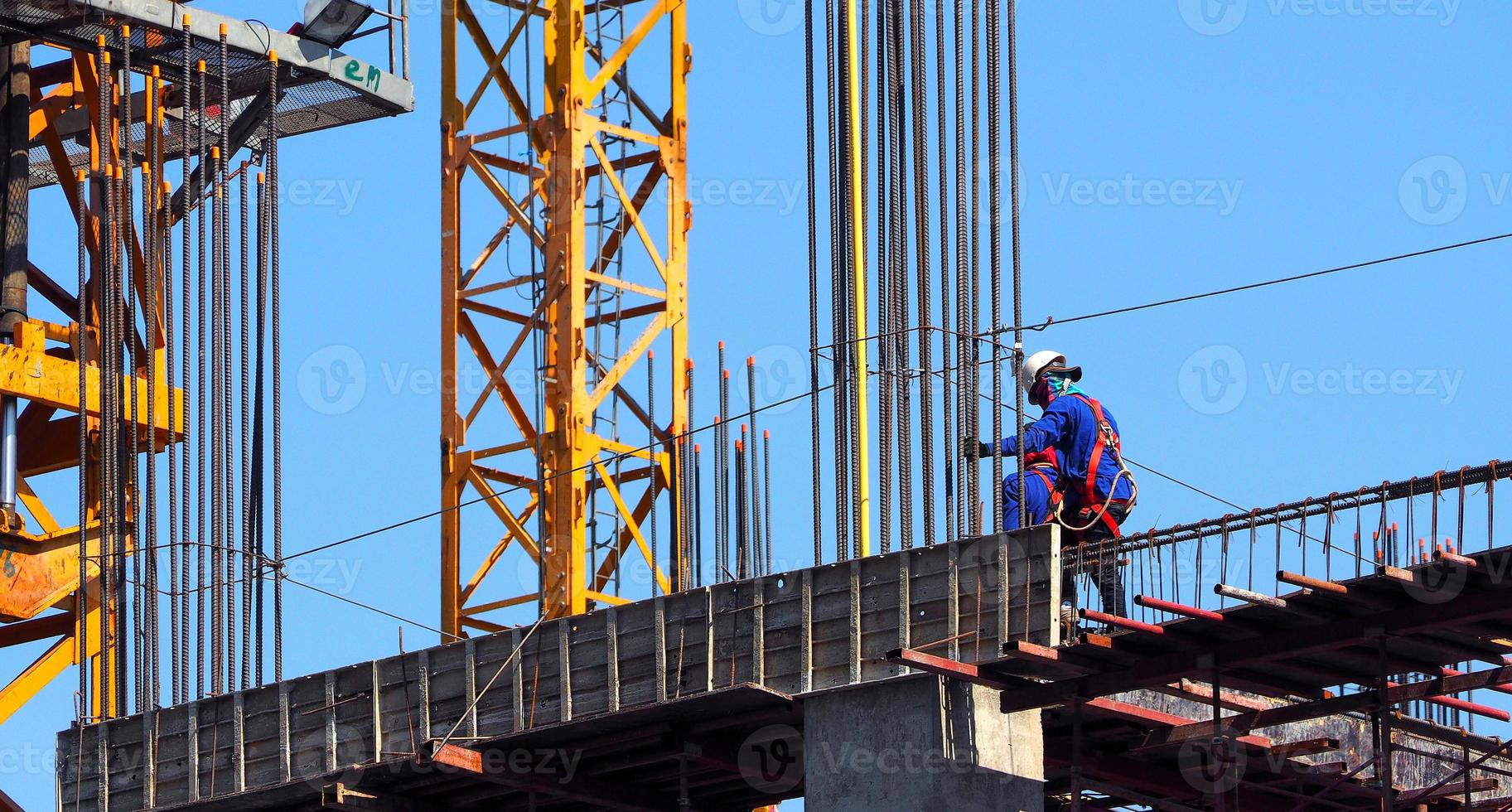 Building construction site and worker standing on steel and concrete material and blue sky. photo