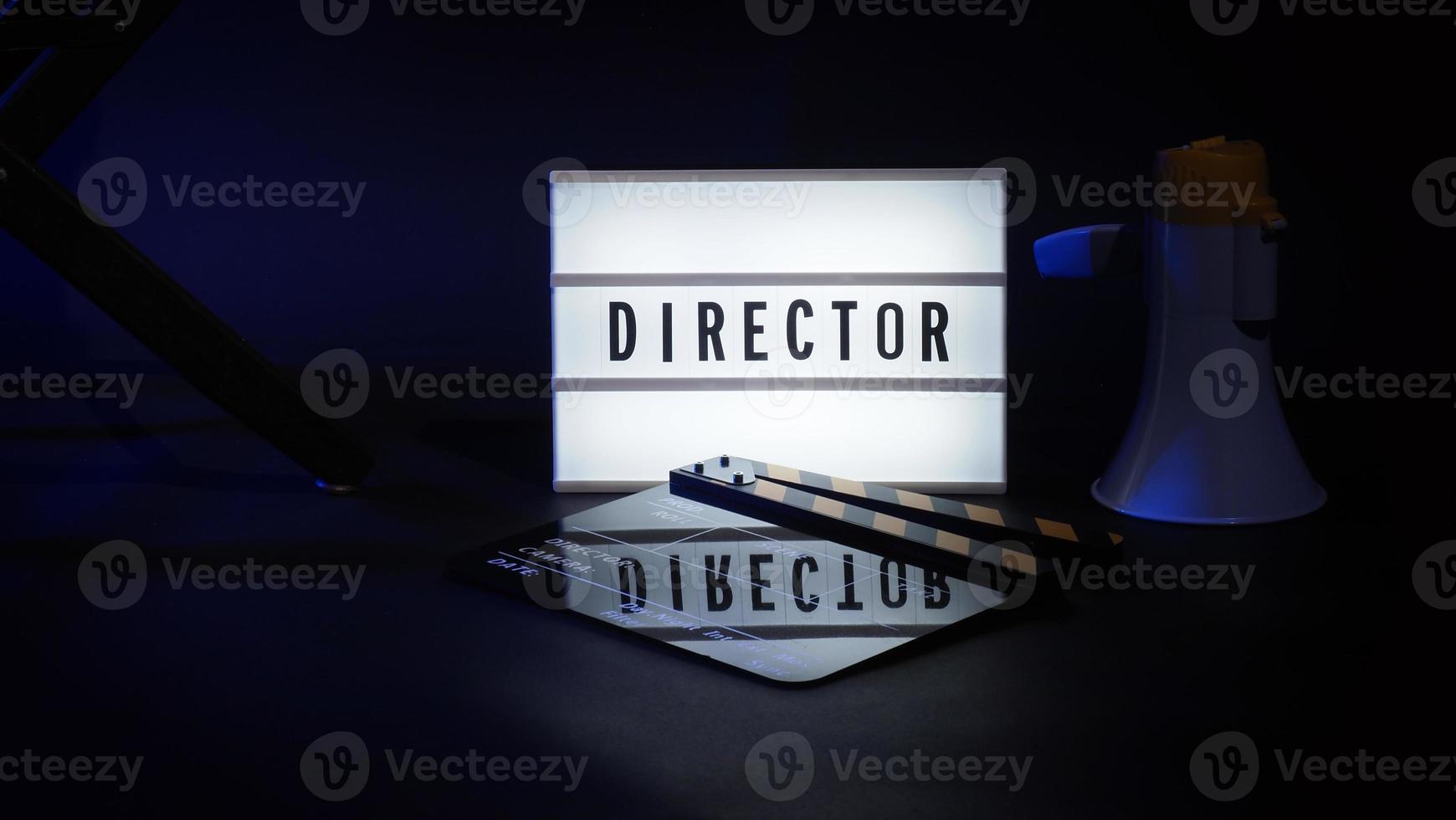 Director chair with cinema lightbox sign Director text on it and clapperboard megaphone photo