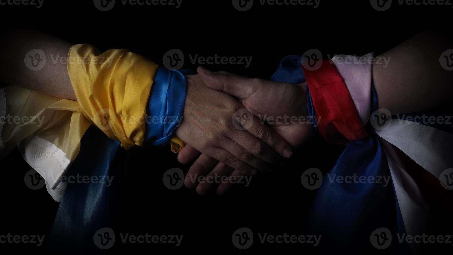 Russian flag and Ukraine flag in hands showing symbol of struggle war photo