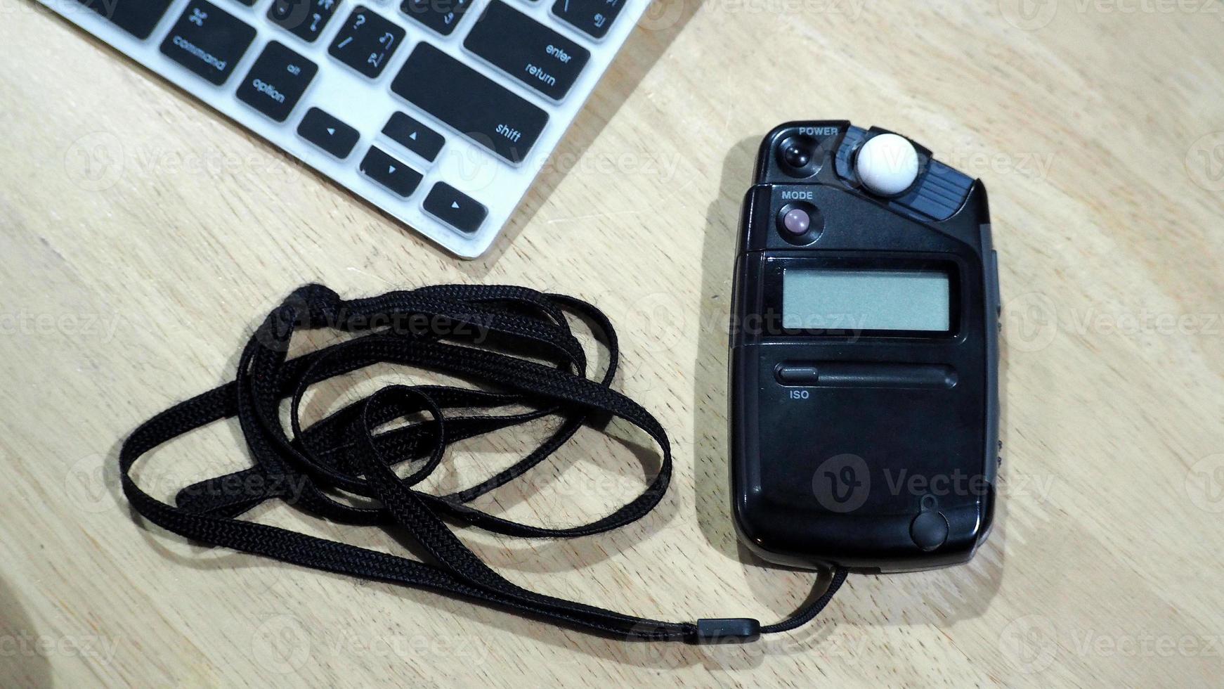 Light meter black color on the wood texture table and top view angle. photo