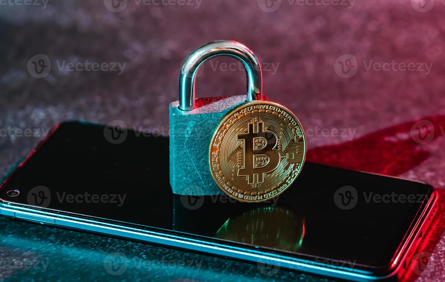 Bitcoin coin and a padlock on a smartphone. photo