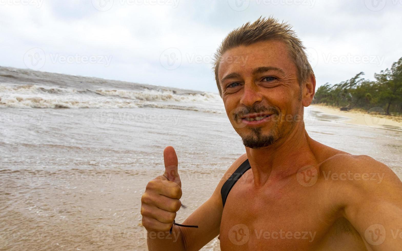 Man is out on beach during hurricane and enjoys Mexico. photo
