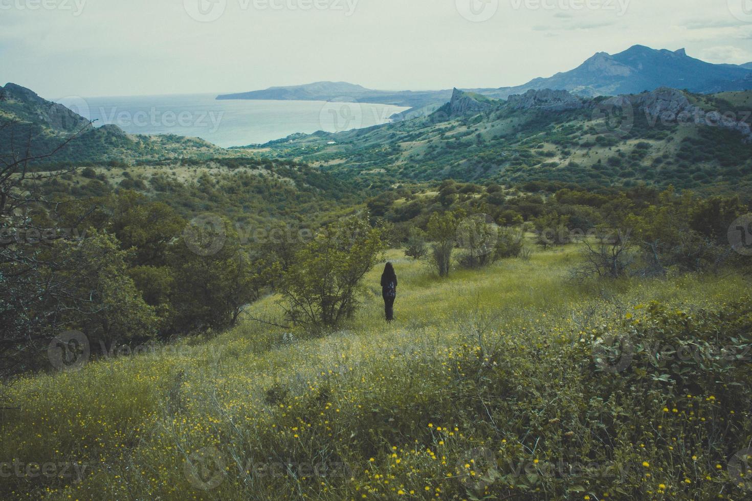 Person standing on mountain slope landscape photo