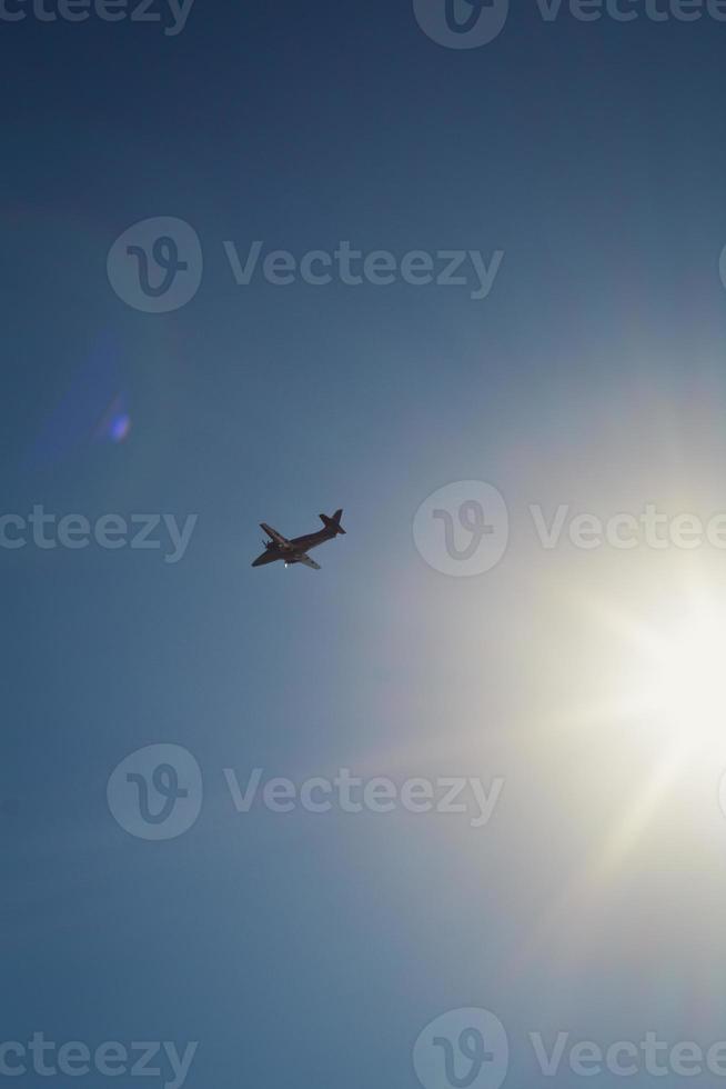 Airplane flying across blue sky landscape photo