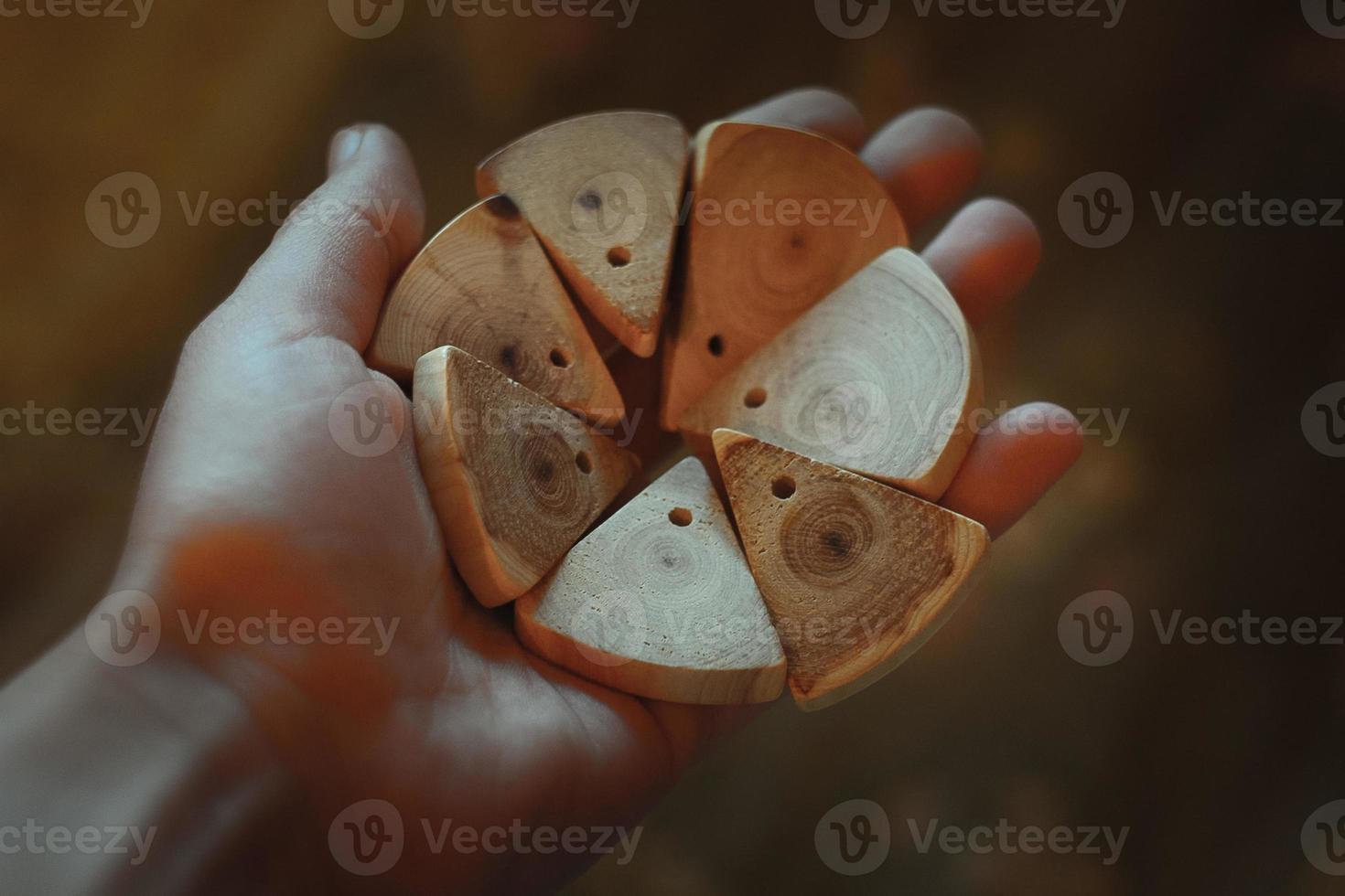 Close up person holding wooden slices for handicraft concept photo