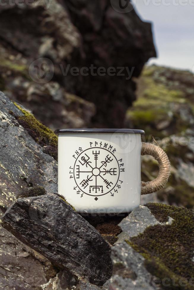 Close up metal cup with runes on rock concept photo