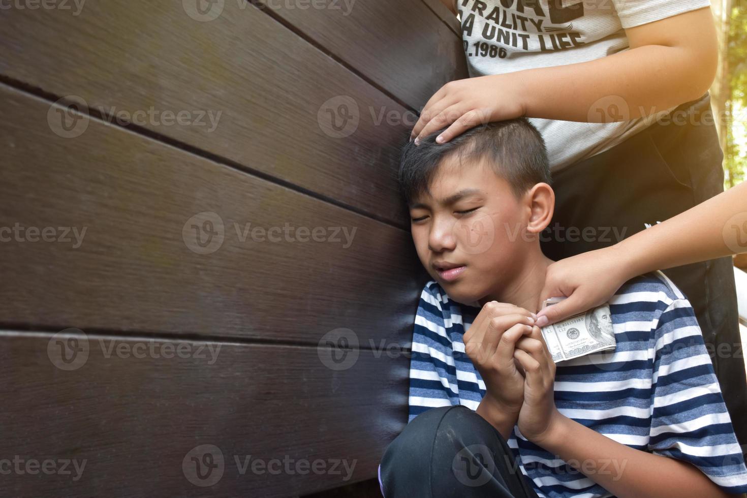 Asian secondary school boy was intimidated by bad habit students at the wall of the bathroom, soft and selecitve focus, bad habit students and teenagers concept. photo