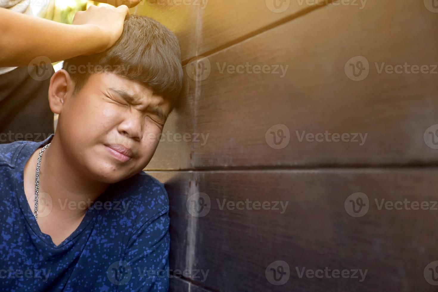 Asian secondary school boy was intimidated by bad habit students at the wall of the bathroom, soft and selecitve focus, bad habit students and teenagers concept. photo