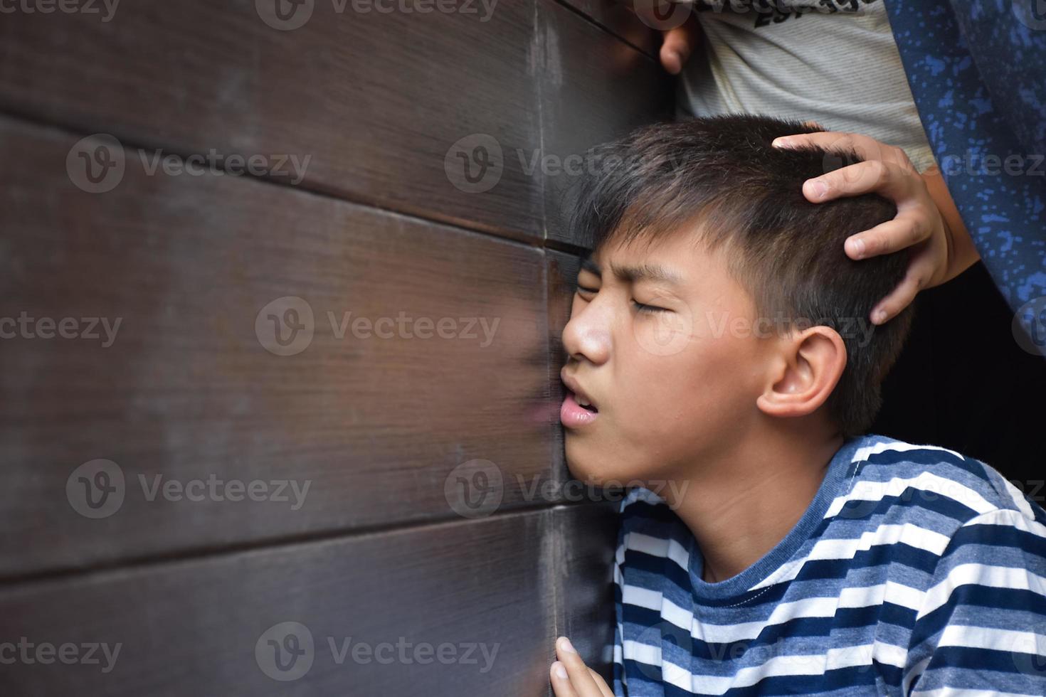 Asian secondary school boy was intimidated by bad habit students at the wall of the bathroom, soft and selecitve focus, bad habit students and teenagers concept. photo