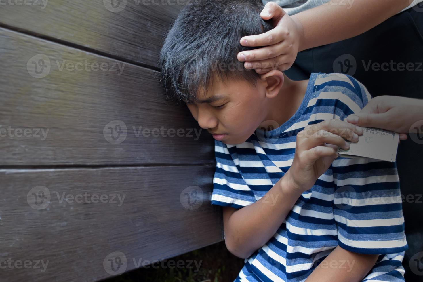 Asian boy was attacked and robbed of dollars by rival teenagers, soft and selective focus, stop asian hate concept. photo
