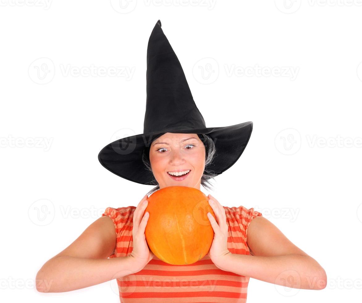 Woman with witch hat and pumpkin for halloween photo