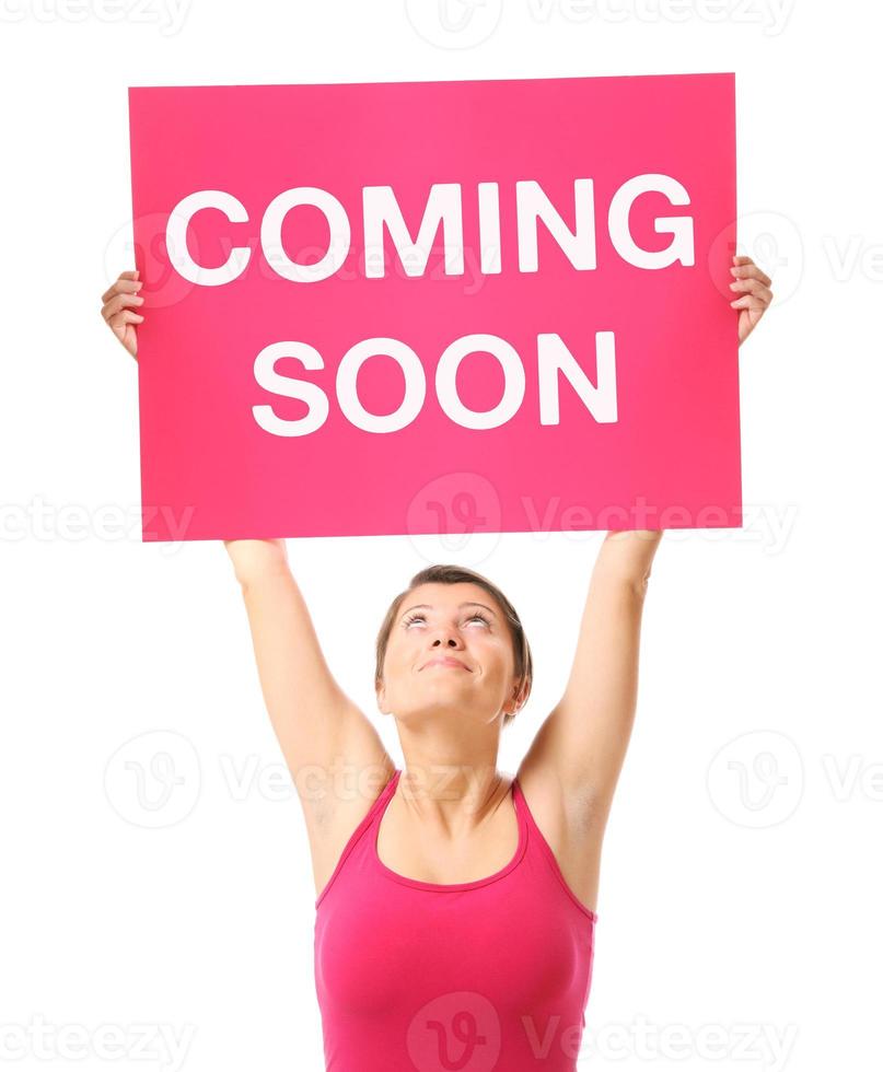 Woman holding a sign Coming soon photo