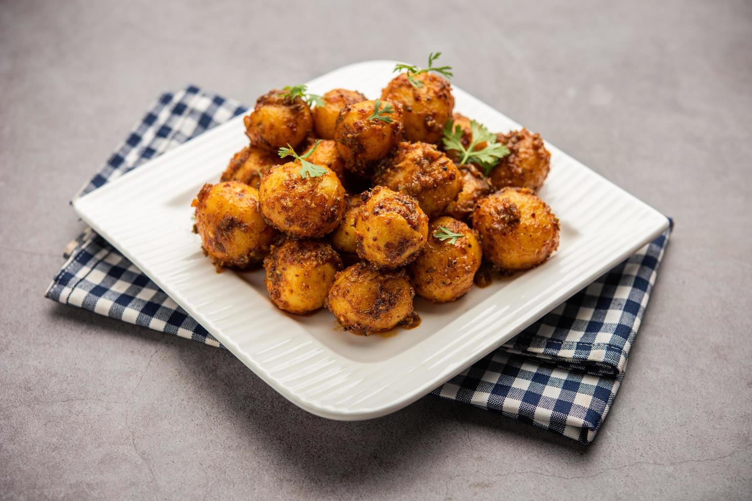 Homemade Roasted Bombay potatoes. Pan fried little baby potatoes or aloo with jeera seeds and coriander in bowl photo