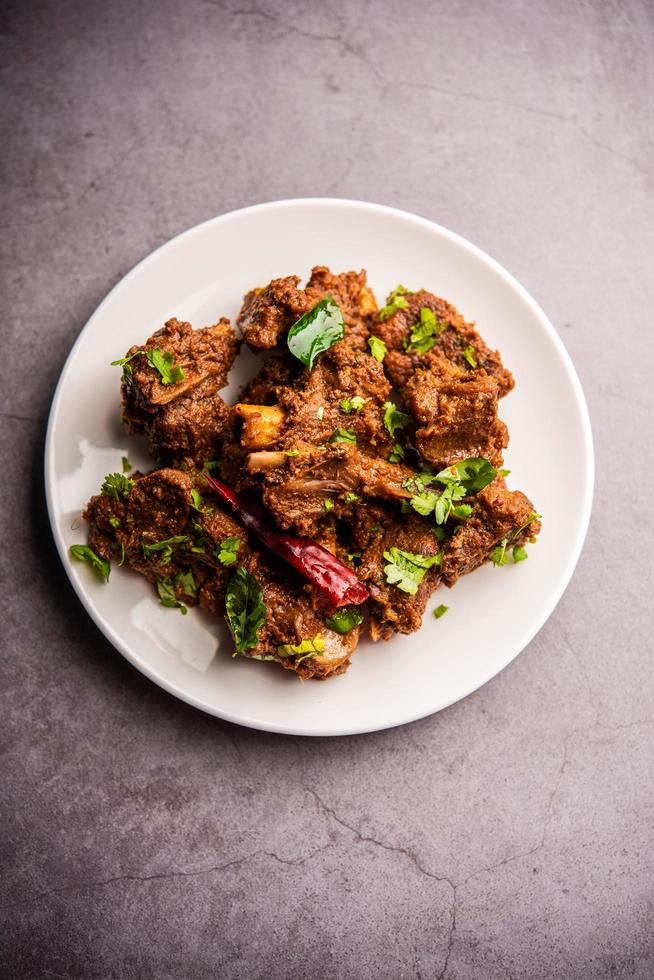 carne de cordero o pollo sukha, murgh picante seco o carne de cabra servida en un plato o bol foto