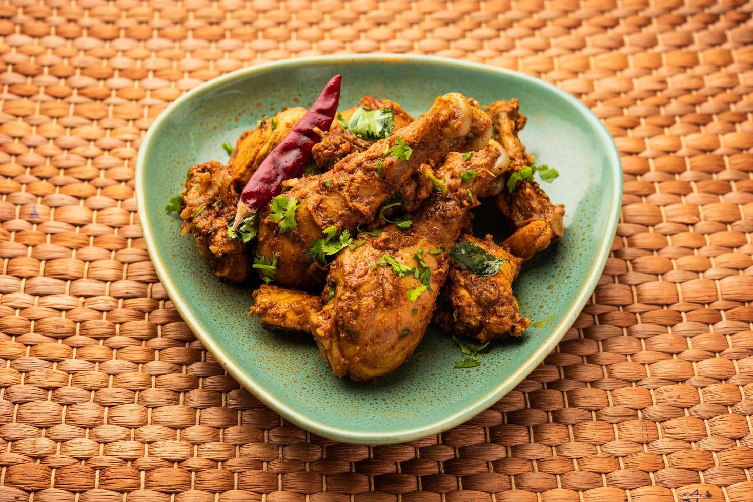 carne de cordero o pollo sukha, murgh picante seco o carne de cabra servida en un plato o bol foto