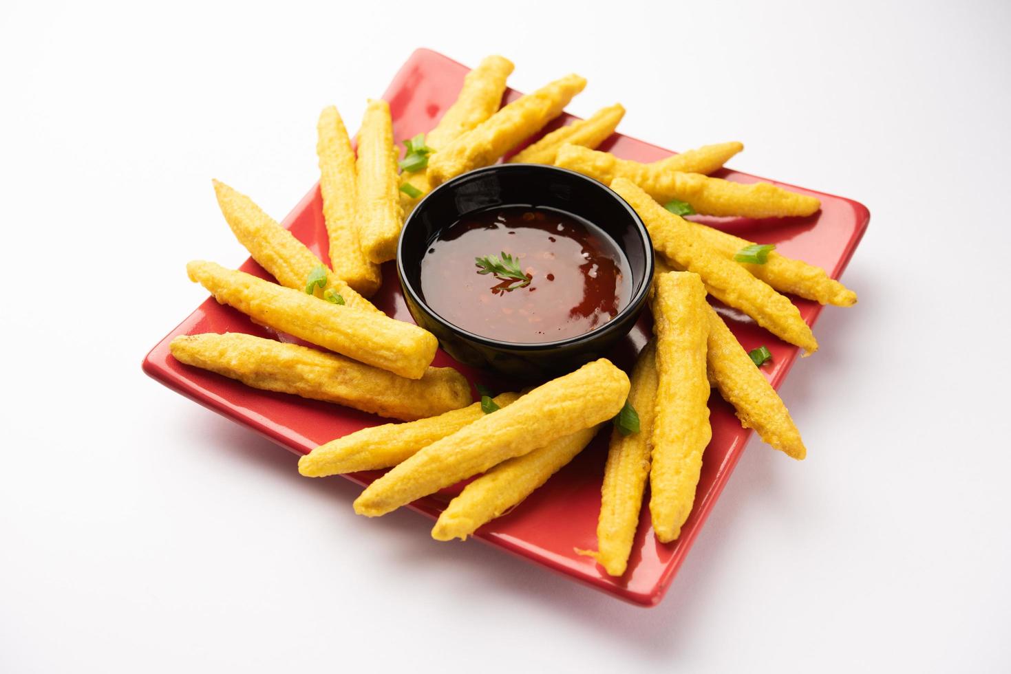 Pakoda de maíz frito crujiente, pakora o buñuelos de maíz para bebés servidos con ketchup, comida india foto