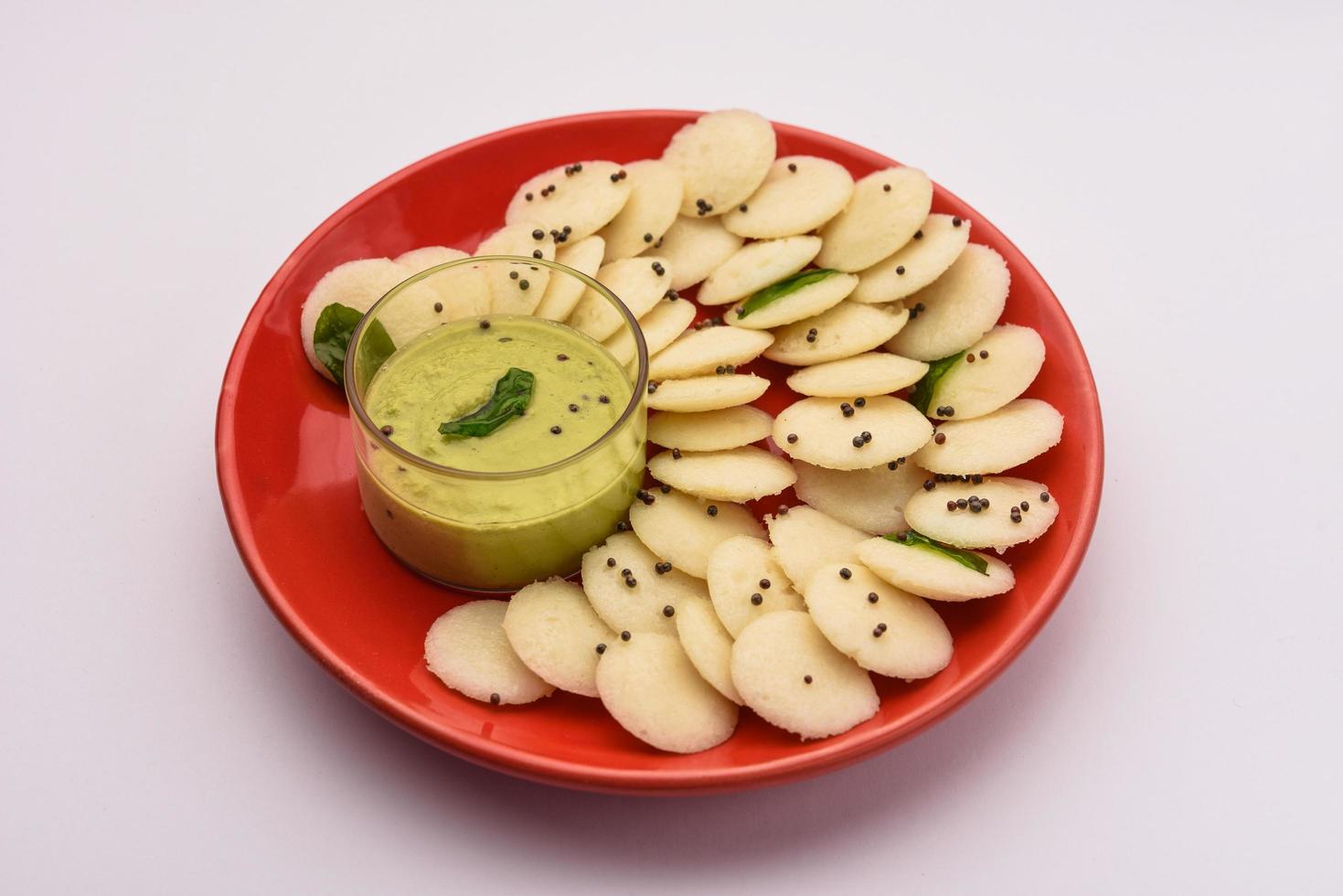 Mini idli is the smaller version of soft and spongy round shaped steamed regular rice idli, also known as button and cocktail idly photo