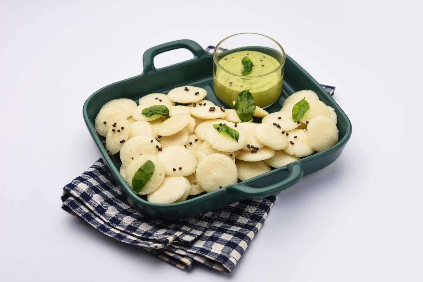 Mini idli is the smaller version of soft and spongy round shaped steamed regular rice idli, also known as button and cocktail idly photo