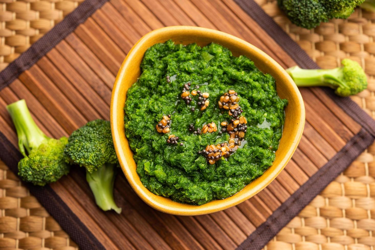 Fresh broccoli chutney or paste, puree in the bowl with raw pieces photo