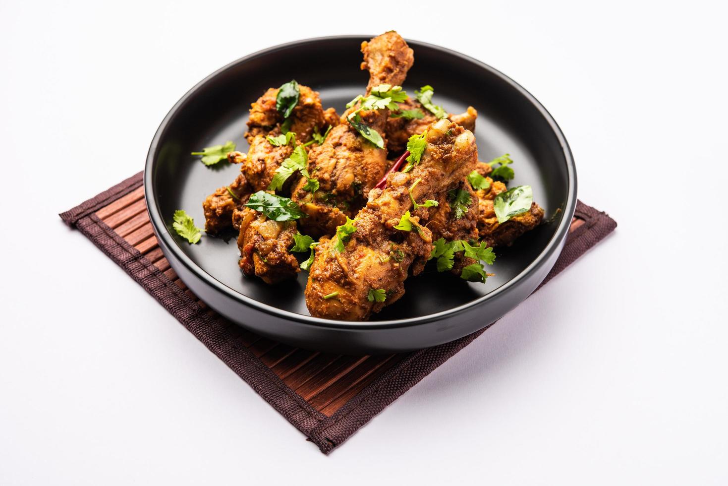 carne de cordero o pollo sukha, murgh picante seco o carne de cabra servida en un plato o bol foto