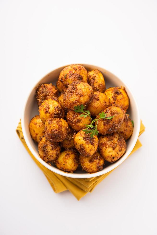 Homemade Roasted Bombay potatoes. Pan fried little baby potatoes or aloo with jeera seeds and coriander in bowl photo