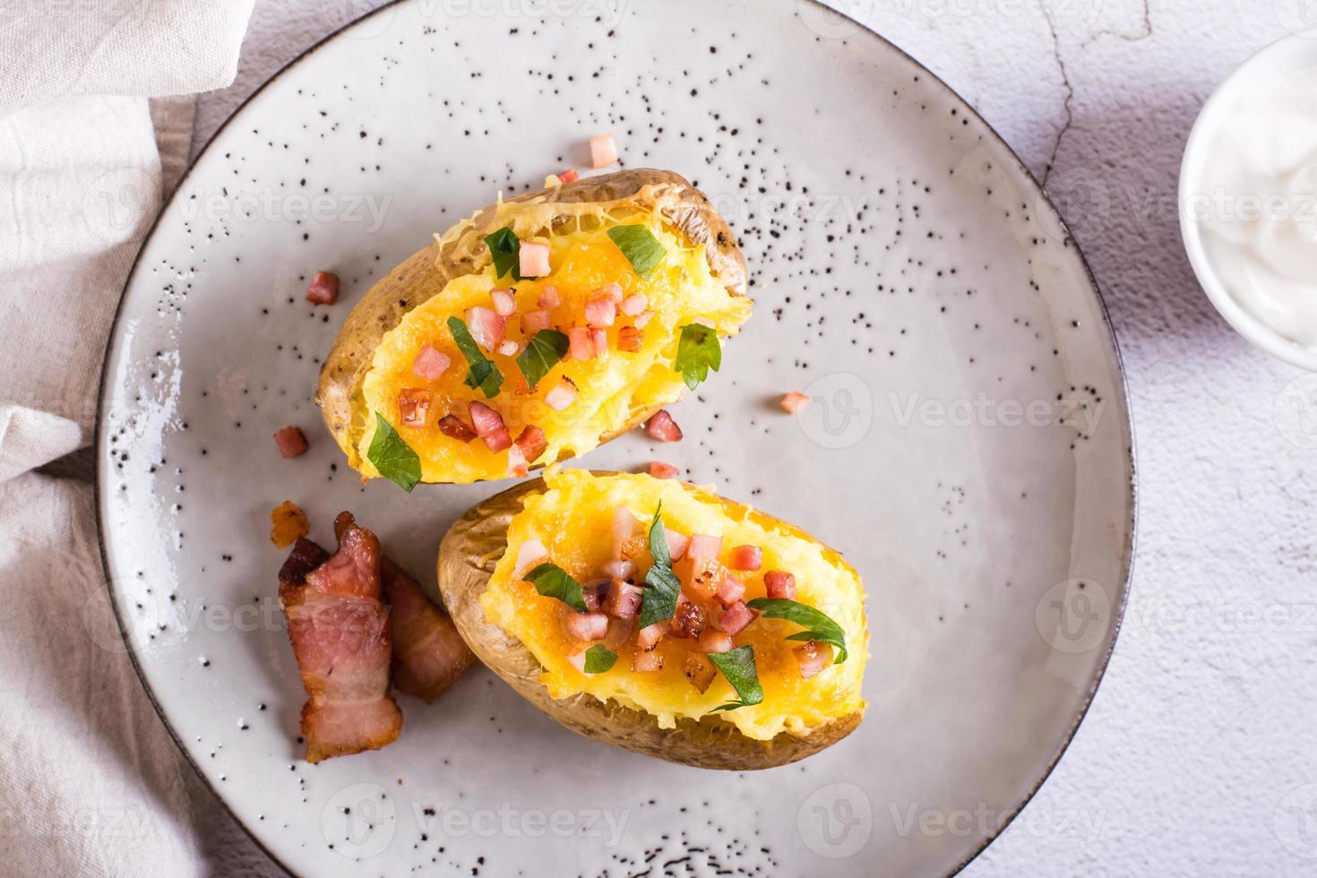 Twice baked potatoes with bacon and cheese on a plate. Homemade dinner. Top view. Closeup photo