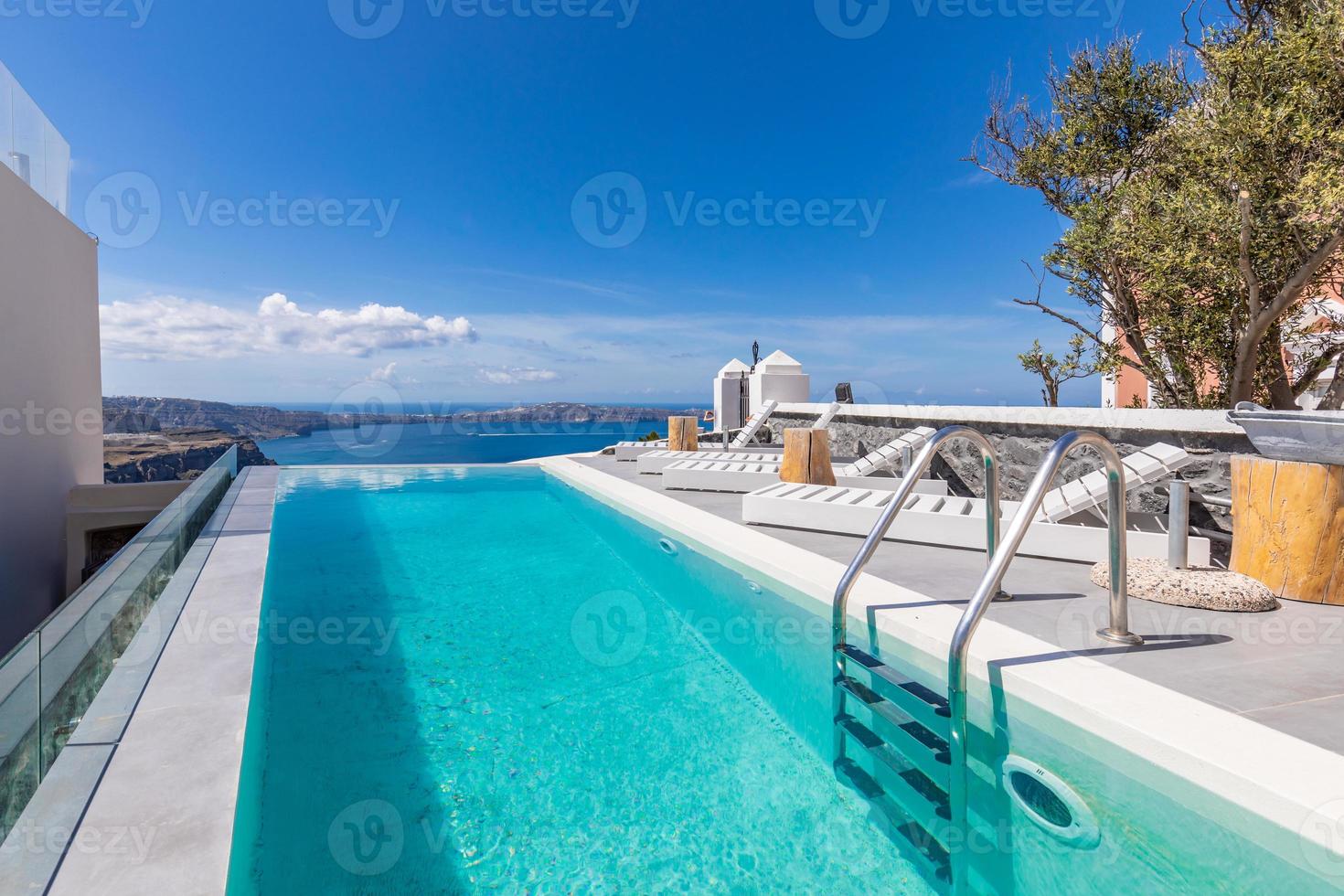 vista de la caldera y la piscina sin fin del hotel de lujo, dosel y vista al mar azul. lujosos viajes y paisajes de vacaciones, arquitectura blanca con edificios elegantes. estado de ánimo de verano, vibraciones foto