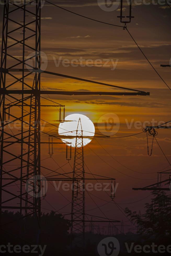 postes de energía en el sol vespertino en verano foto