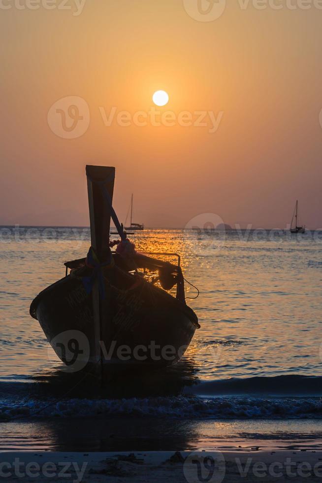 Sunset over the sea with boat silhouette photo