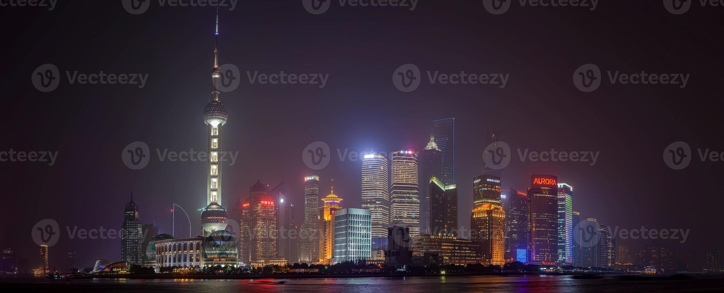 Panoramic view of the skyline of Shanghai's Pudong district from the famous promenade the Bund in the evening photo