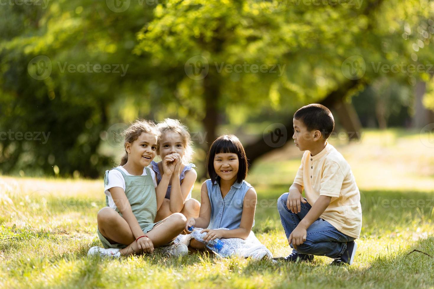 Group of asian and caucasian kids having fun in the park photo