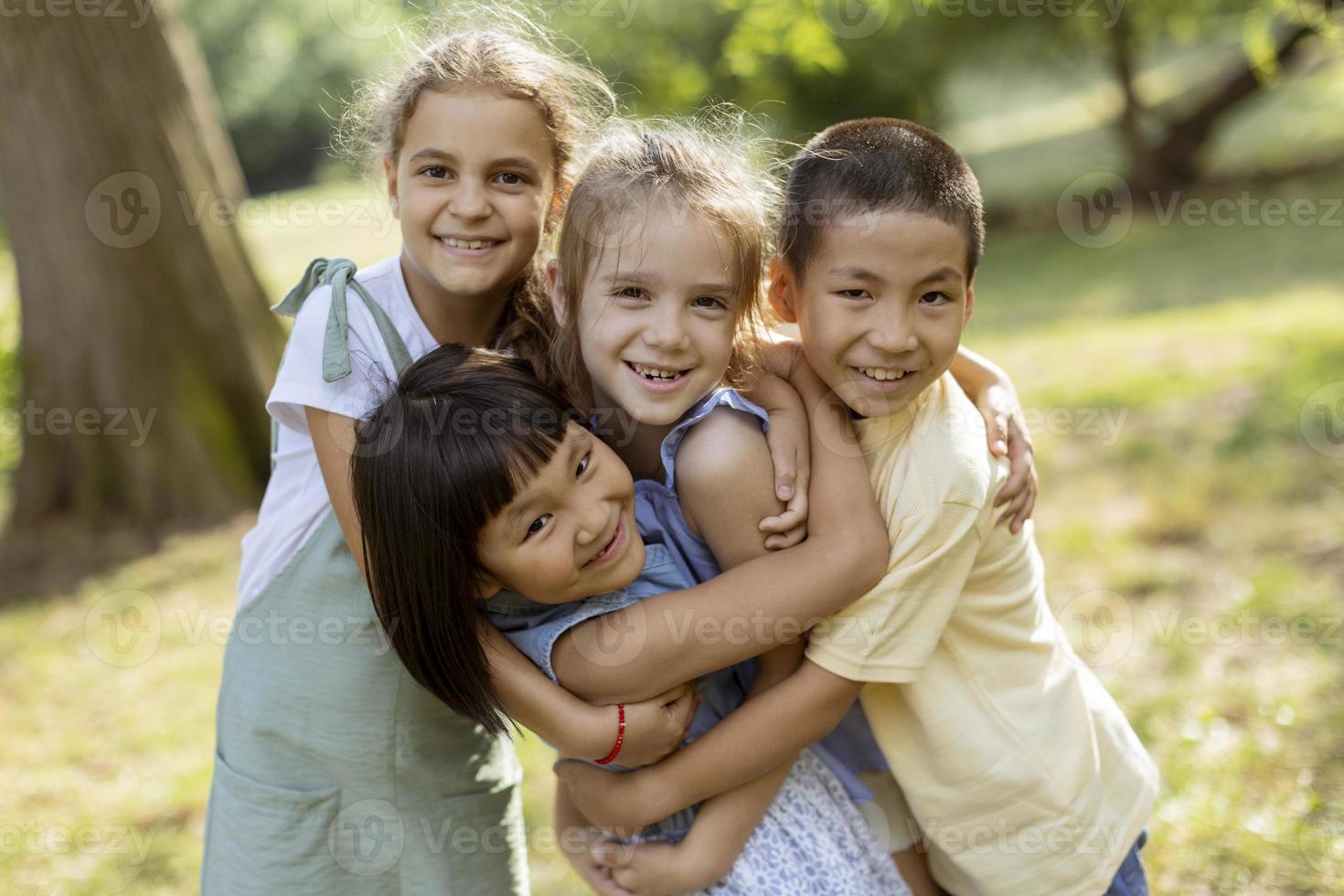 grupo de niños asiáticos y caucásicos divirtiéndose en el parque foto