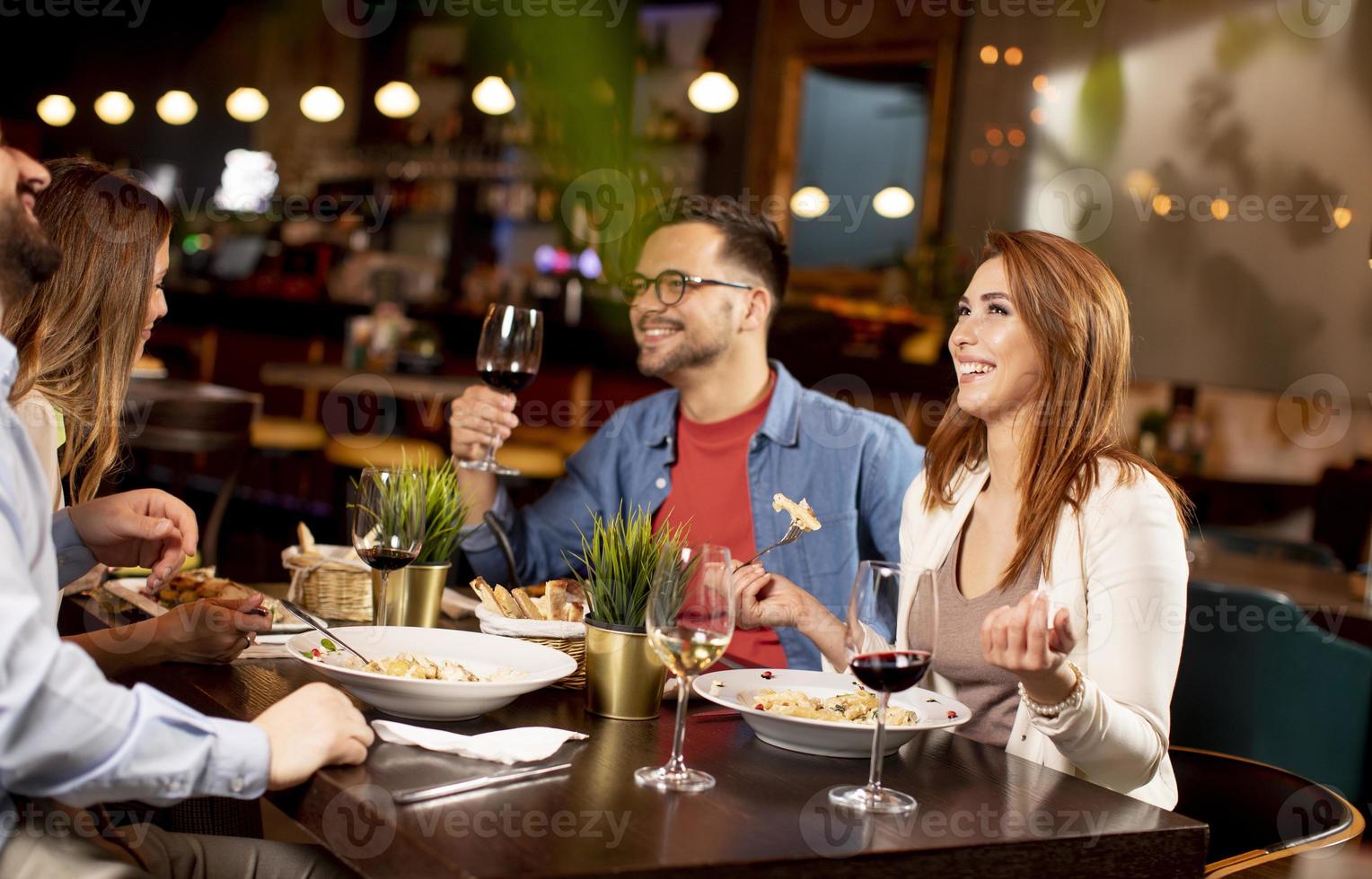 Young people having dinner in the restaurant photo