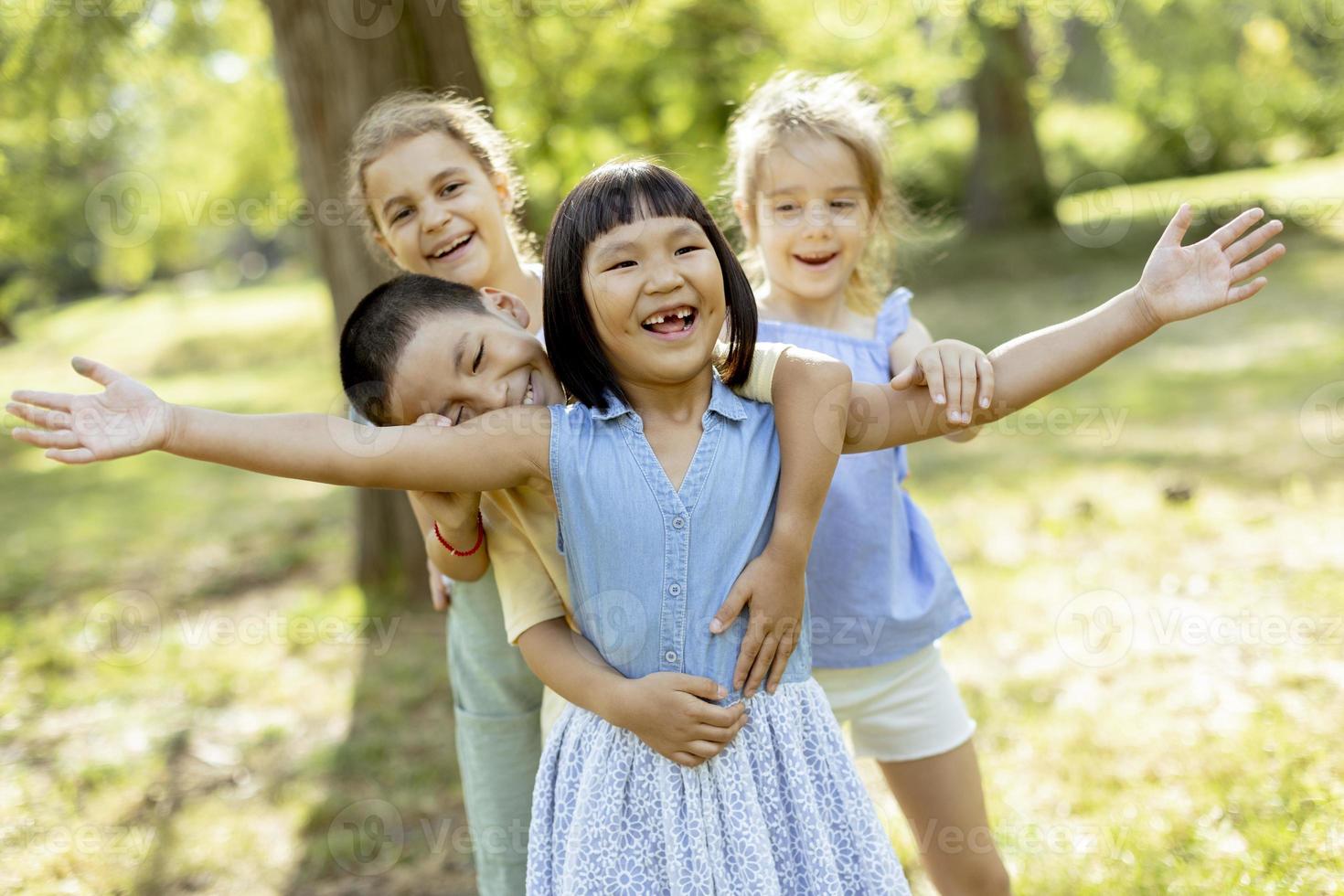 grupo de niños asiáticos y caucásicos divirtiéndose en el parque foto