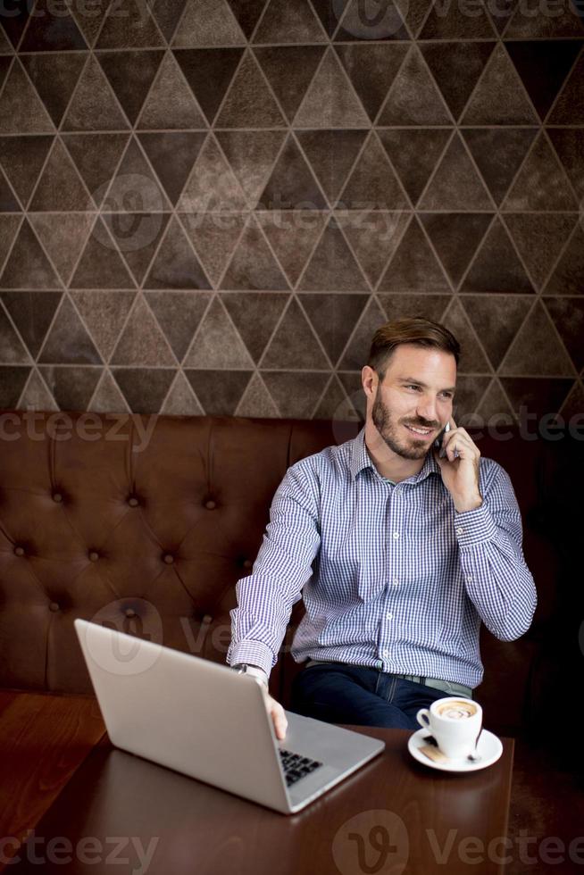 Young man working on laptop in the cafe photo