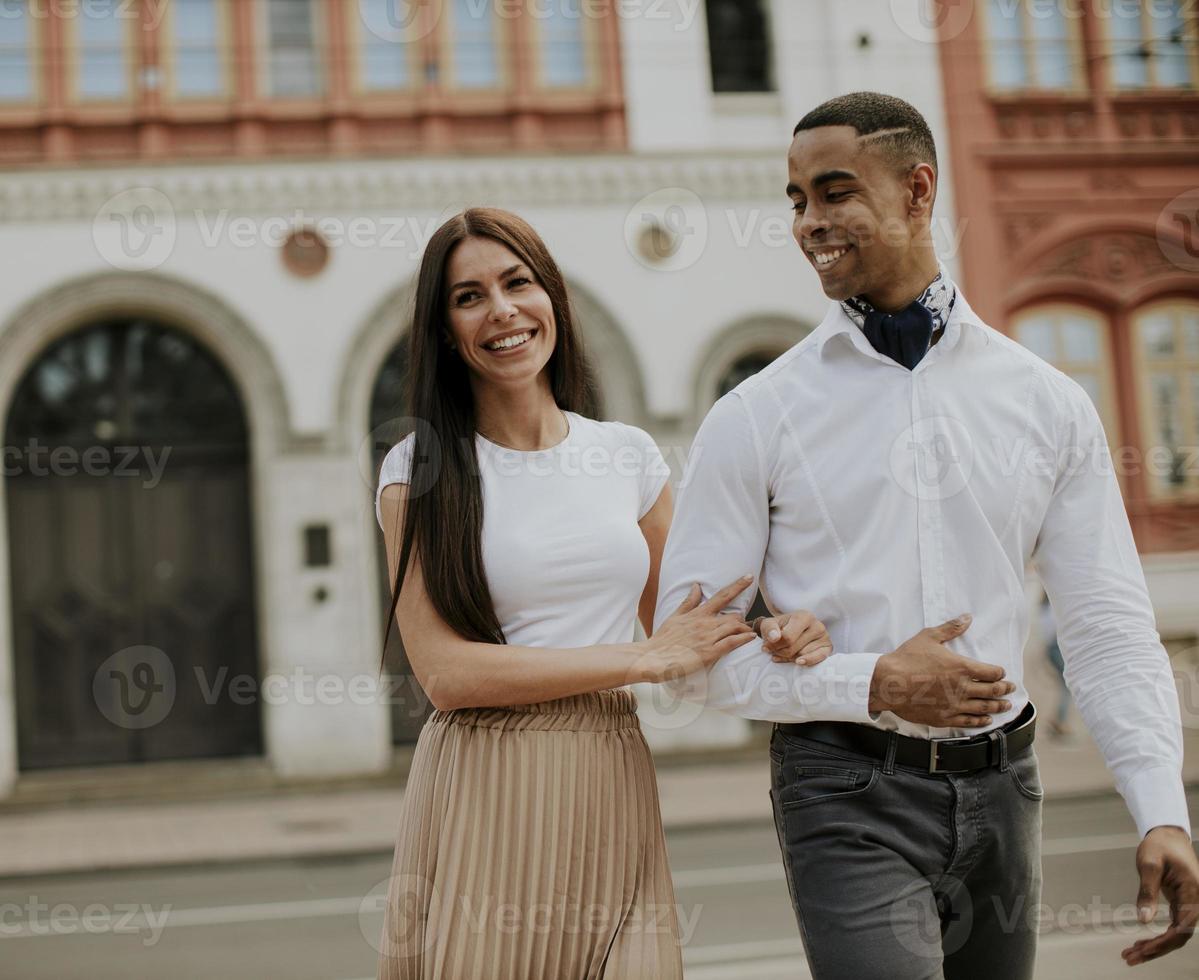 joven pareja multiétnica caminando por la calle foto