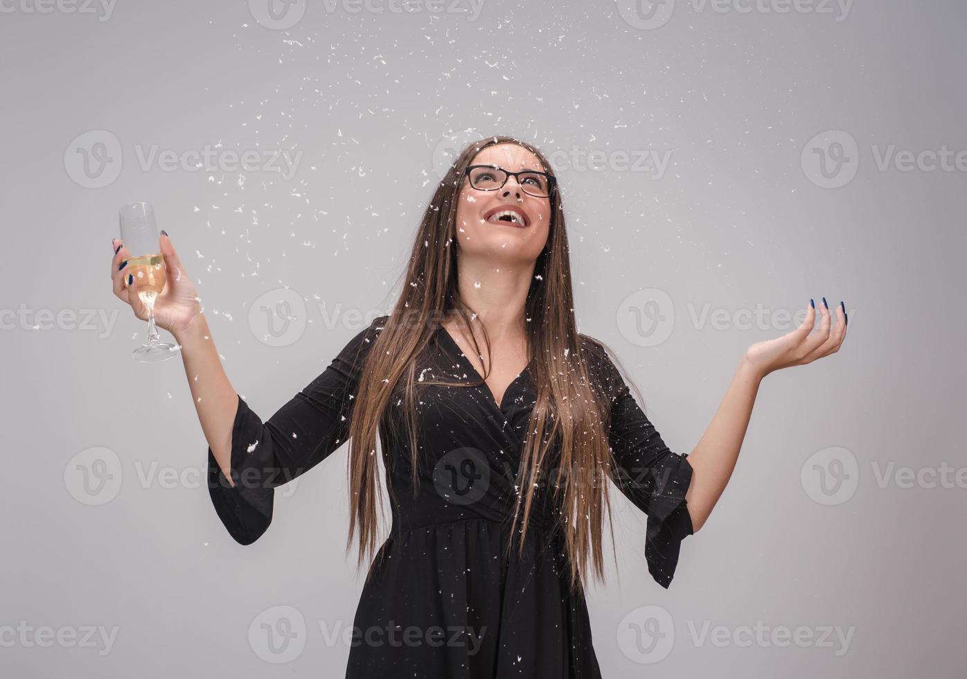 Beautiful woman celebrating New Year with confetti and champagne photo