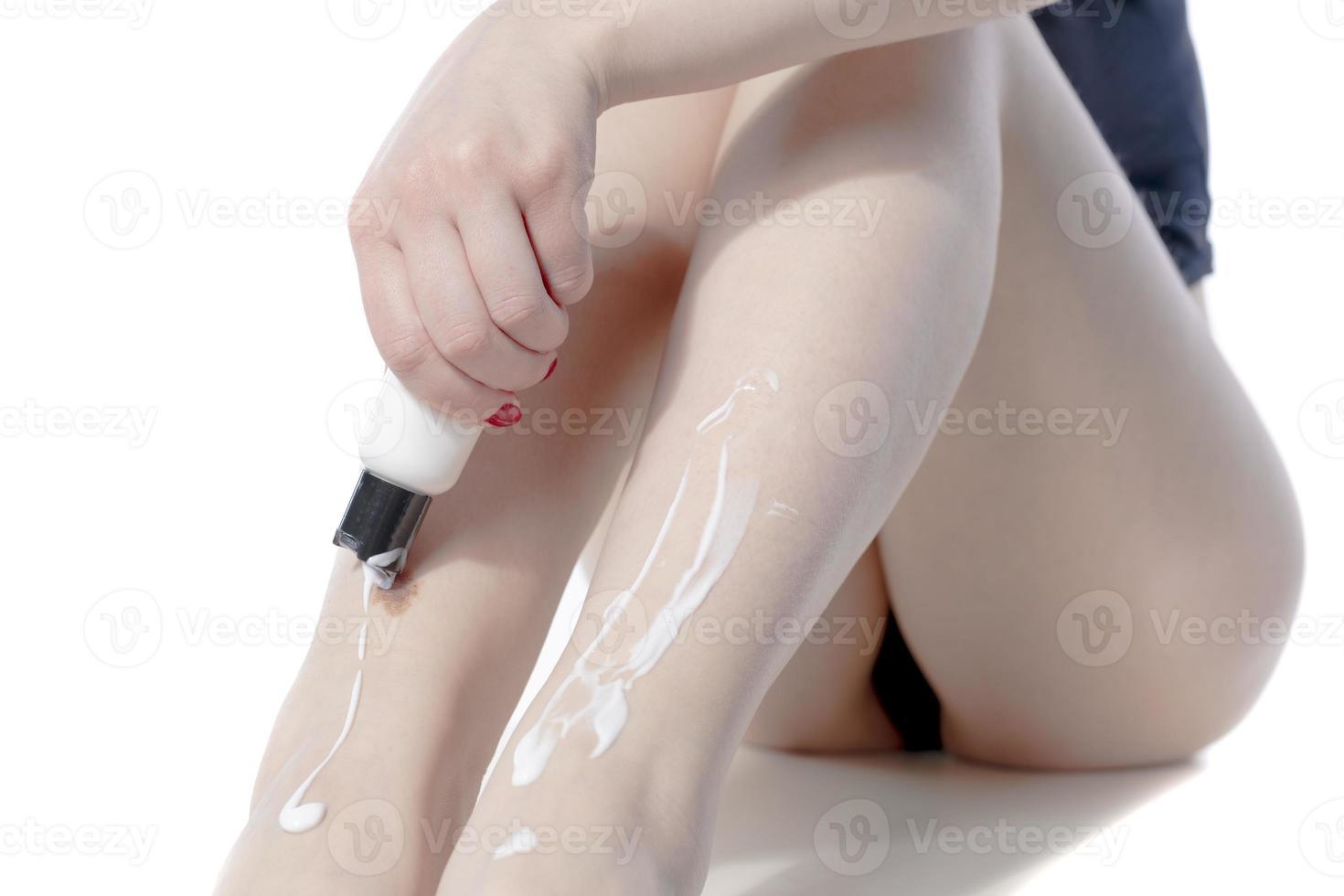 Woman Applying Cosmetic Foot Cream, Applying Cosmetic Cream after depilation, Skin Care. photo