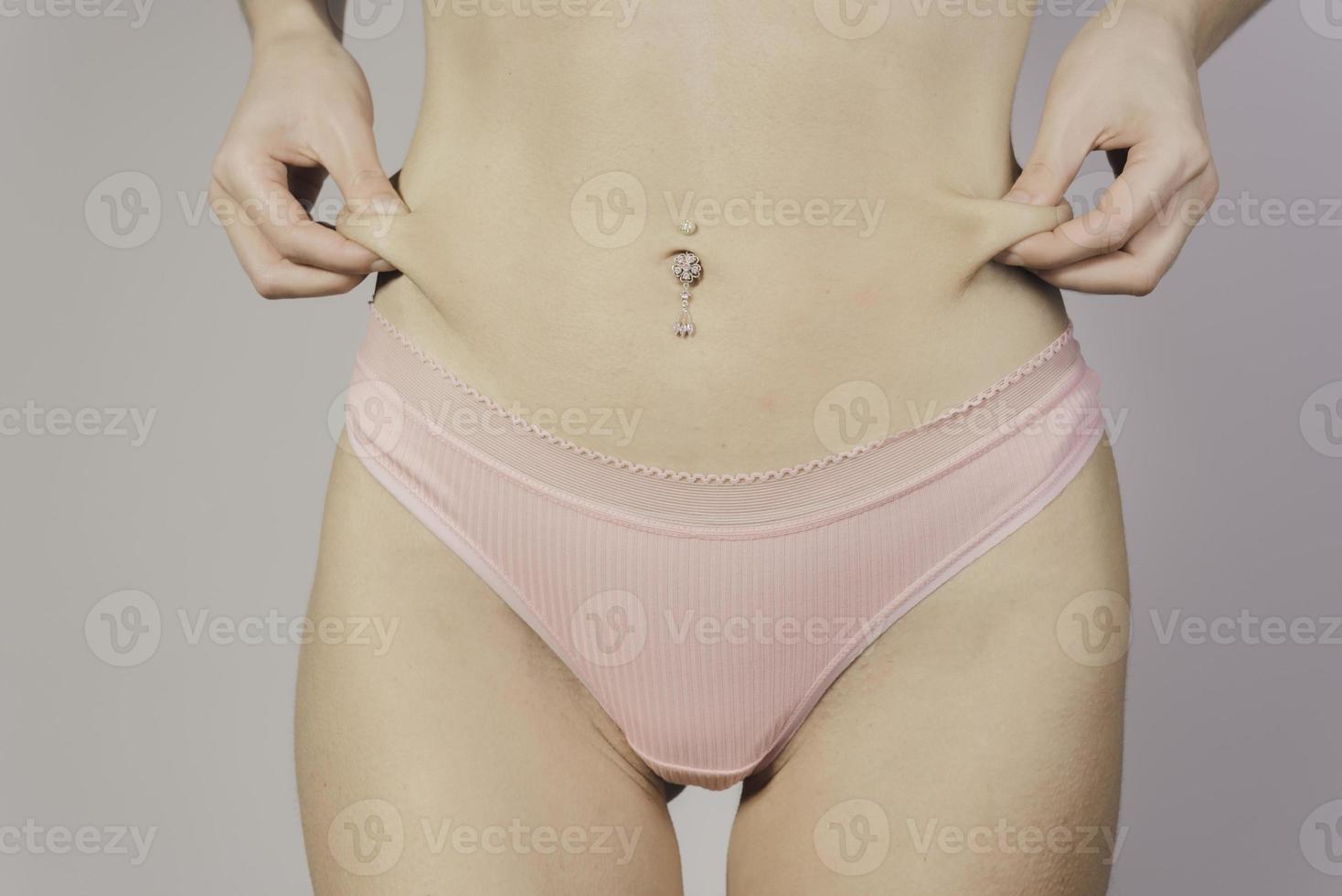 Fit Sexy Female With Hand Pinching Skin Measuring Body Fat. photo