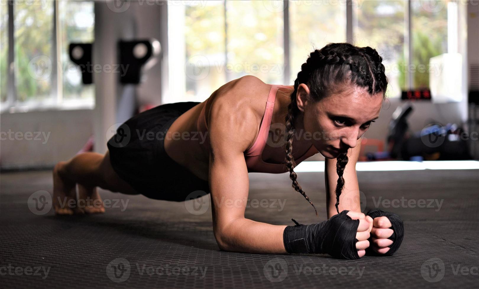 Woman on boxing training doing push ups photo