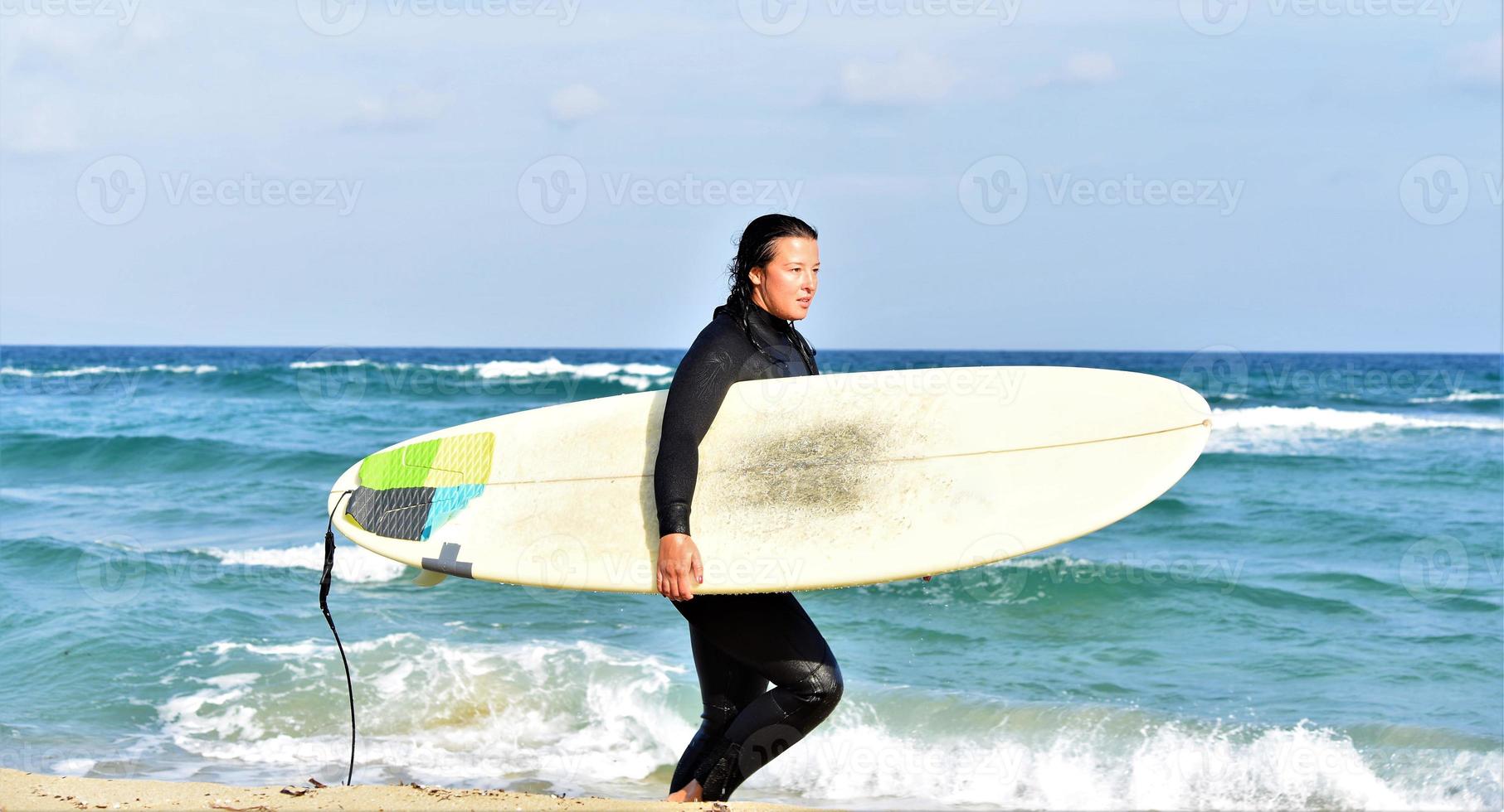 Beautiful sexy surfer girl on the beach photo