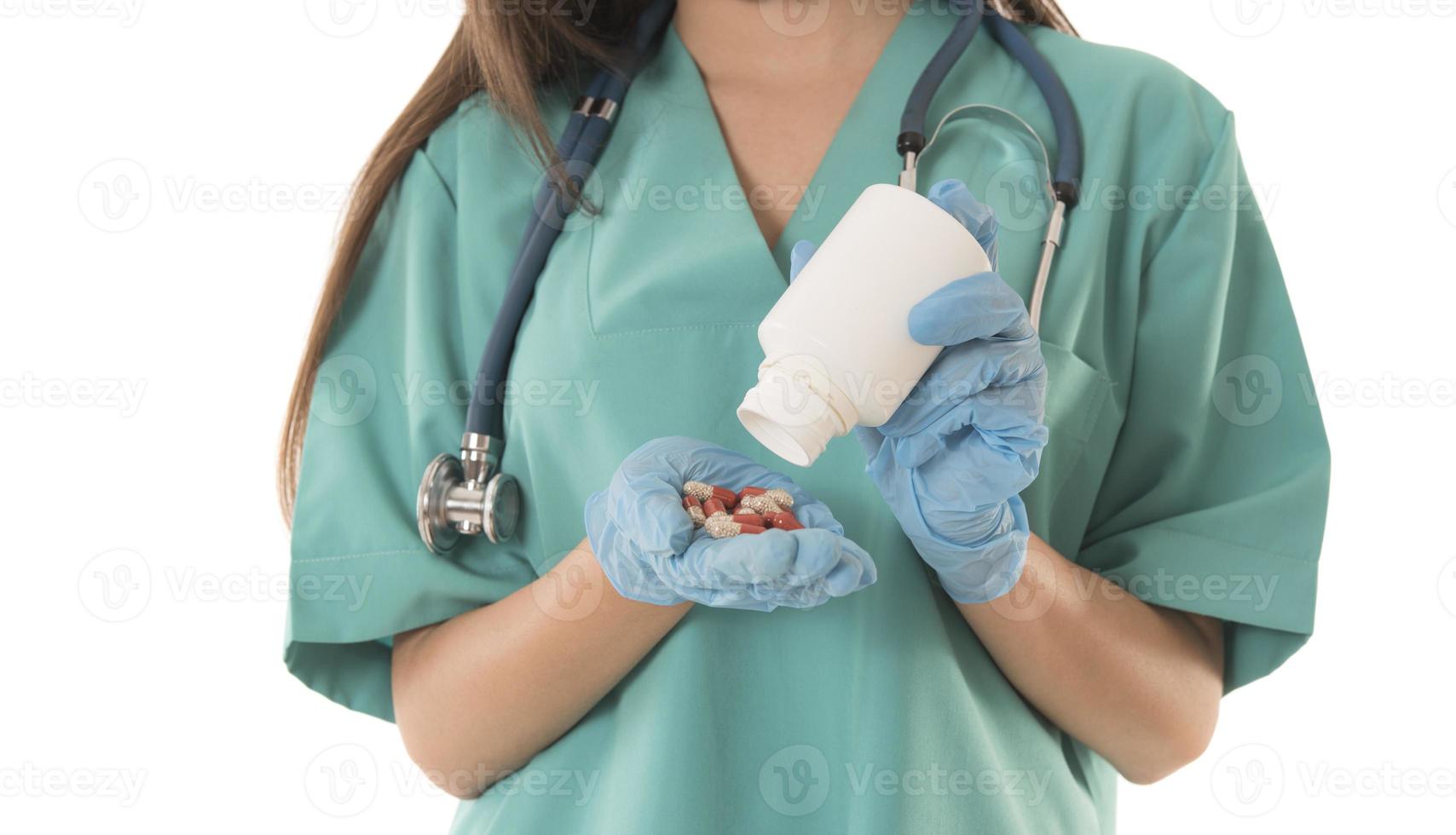Portrait of professional female smiling doctor in green scrubs holding a brown pill bottle Medical Care photo
