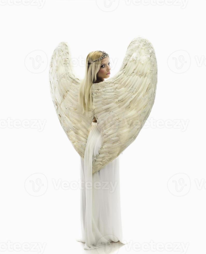 beautiful young model with big angel wings sitting in the studio. white background photo