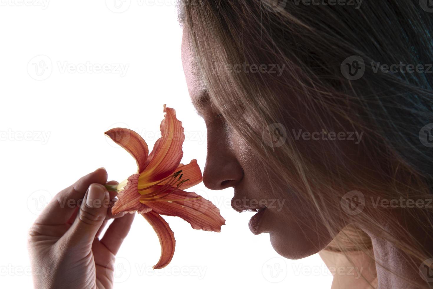 retrato artístico de una mujer sosteniendo una flor de lirio. concepto de belleza. aislado sobre fondo blanco foto